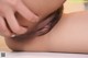 A close up of a woman's hairy pussy with her hands on her butt.