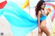 A woman in a blue bikini standing on a beach.