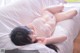 A woman laying on top of a white bed.