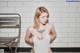 A woman in a white bodysuit with a tattoo on her chest.